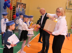 Kobieta i mężczyzna wręczają upominki dzieciom 