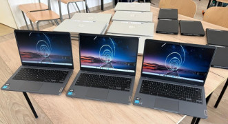 Trzy laptopy stoją na szkolnych ławkach 