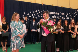 Mężczyzna trzyma w ręku bukiet kwiatów i przemawia