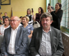 Grupa osób siedzi na krzesłach 