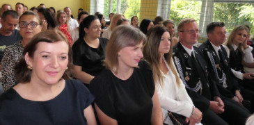 Grupa osób siedzi na krzesłach 