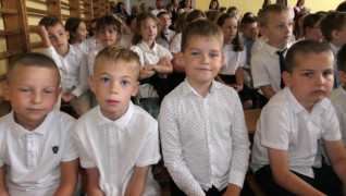 Grupa dzieci siedząca obok siebie