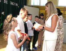 Kobieta wręcza uczniom nagrody