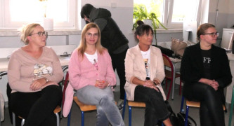 Kobiety siedzą na krzesłach. Uczestniczki warsztatów 
