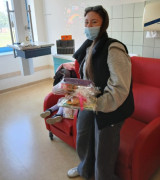 Dziewczynka w maseczce. W ręku trzyma zabawki. 