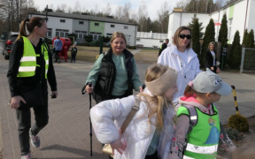 Osoby idą obok siebie drogą 