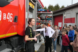 Druhna tłumaczy dzieciom co znajduje się na stanie strażackiego wozu bojowego