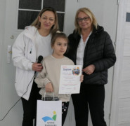 Dwie kobiety i dziewczynka. Dziewczynka trzyma w ręku dyplom