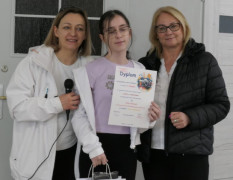 Dwie kobiety i dziewczynka. Dziewczynka trzyma w ręku dyplom