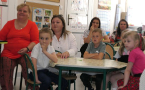 Dorośli i dzieci siedzą przy stolikach 