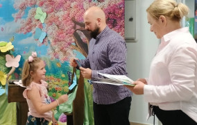 Kobieta i mężczyzna gratulują małej dziewczynce 