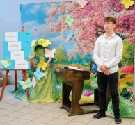 Chłopic w białej koszuli i czarnych spodniach stoi i recytuje wiersz 