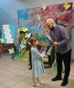 Mężczyzna wręcza małej dziewczynce dyplom 