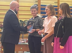 Trzy kobiety stoją obok siebie. Gratulacje składa im mężczyzna 