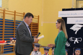 Kobieta i mężczyzna. Mężczyzna wręcza kobiecie dokument 