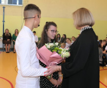 Uczniowie wręczają bukiet kwiatów pani dyrektor 