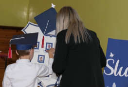 Kobieta i uczeń przy symbolicznej szkolnej tarczy