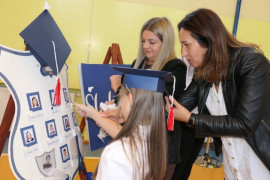 Dwie kobiety i uczennica przy symbolicznej tarczy