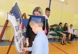 Chłopiec i kobieta przy symbolicznej szkolnej tarczy