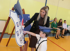 Chłopiec i kobieta przy symbolicznej szkolnej tarczy