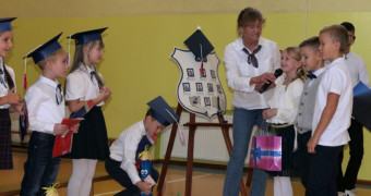 Grupa osób stoi obok siebie: dzieci i jedna osoba dorosła 