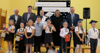 Grupa osób stoi obok siebie: dorośli i dzieci 