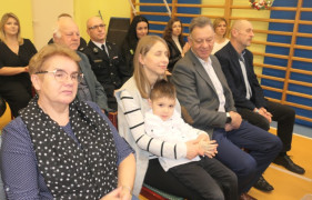 Grupa osób siedząca obok siebie na krzesłach