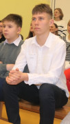 Pięciu chłopców siedzi obok siebie na ławce