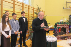 Uczniowie i ksiądz czytający fragment Pisma Świętego  