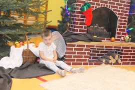 Mały chłopiec siedzący przy kominku