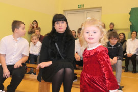 Kobieta i mała dziewczynka. Kobieta siedzi na ławce, dziewczynka stroi 