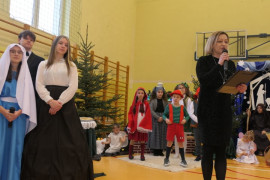 Uczniowie i kobieta. Kobieta przemawia przez mikrofon