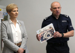 Mężczyzna i kobieta stoją obok siebie. Mężczyzna trzyma w ręku dokumenty