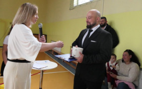 Kobieta i mężczyzna. Kobieta przekazuje mężczyźnie kubek na szczęście 