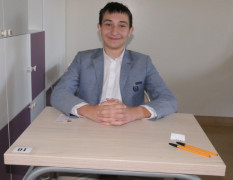 Chłopiec siedzi w szkolnej ławce