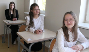 Uczennice siedzą w szkolnych ławkach 