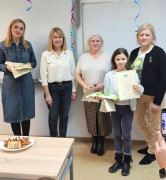 Cztery kobiety i dziewczynka. Dziewczynka trzyma w ręku dyplom 