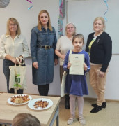Cztery kobiety i mała dziewczynka. Dziewczynka trzyma w ręku dyplom 