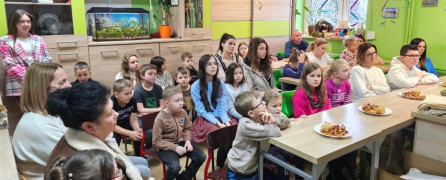 Dzieci siedzą w szkolnych ławkach 