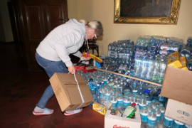 Pomieszczenie, kobieta, duża ilość wody w butelkach 