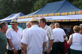 Stoisko wystawiennicze i grupa osób przed nim 