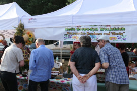 Stoisko wystawiennicze i osoby przed nim 