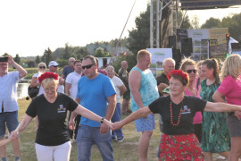 Grupa tańczących osób na świeżym powietrzu 